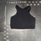 Black tank top on a gray floor with measurement markings