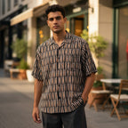 O.M.THRIFT vintage short sleeve button down shirt with cigar print and vertical stripes on a man outdoors.