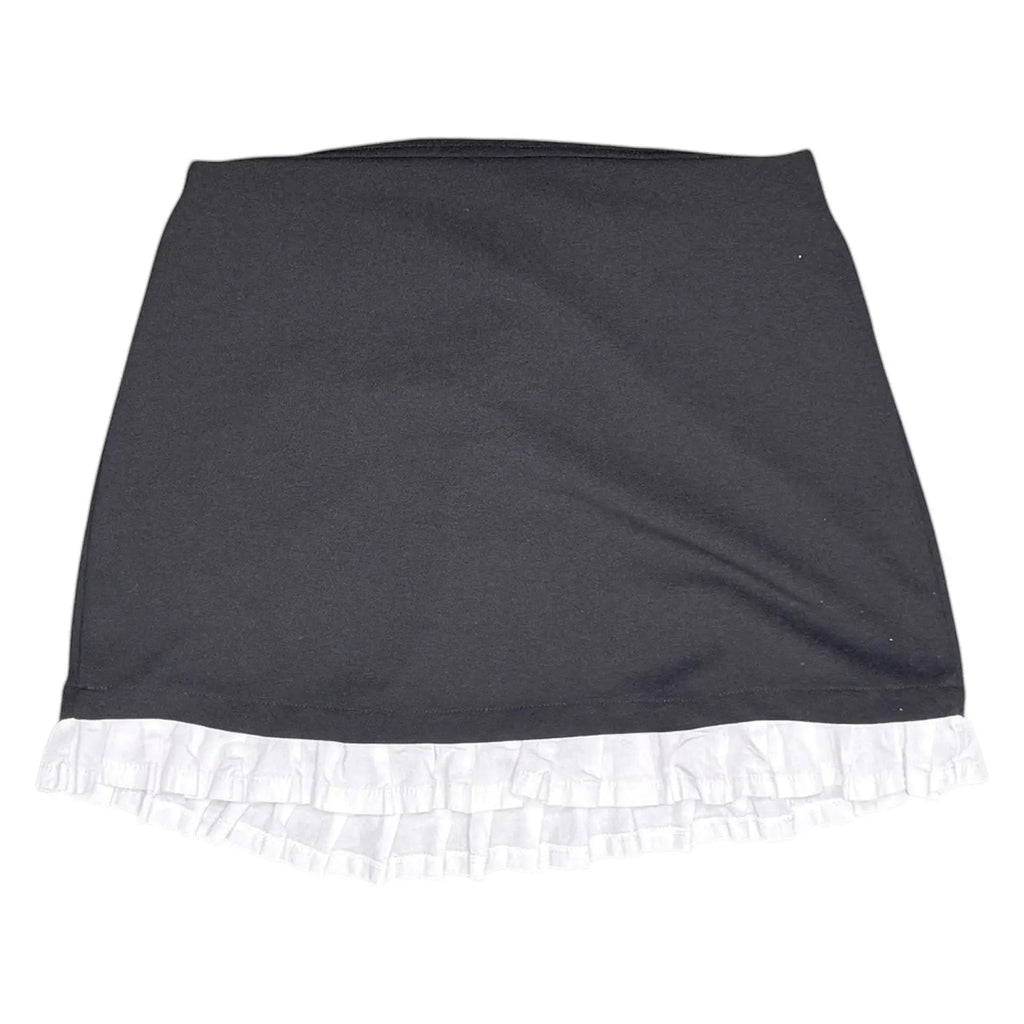 The Room Collective black mini skirt with white ruffled hem. High-waisted, slim fit, stretchy polyester/spandex blend with cotton ruffle.