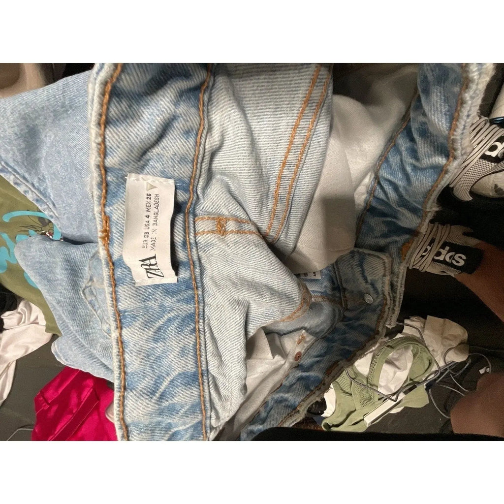 The Room Collective Zara high rise light wash denim shorts with five-pocket styling and zip fly.