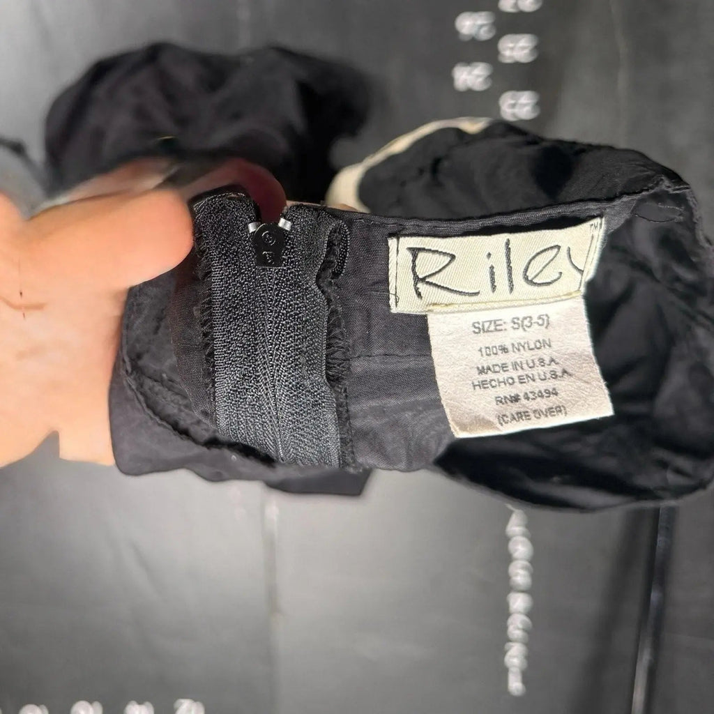 The Room Collective Riley black ruched nylon parachute skirt with back zipper and size S tag. Adjustable hem.