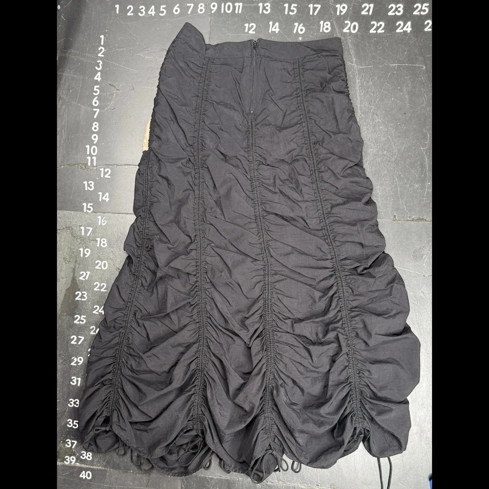The Room Collective Riley black ruched nylon parachute skirt with adjustable drawstring hem and back zipper closure. Size S.