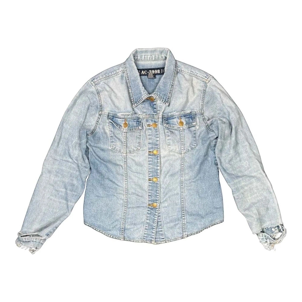 The Room Collective light wash denim trucker jacket with distressed cuffs and hem, featuring dual chest pockets and gold-tone buttons.